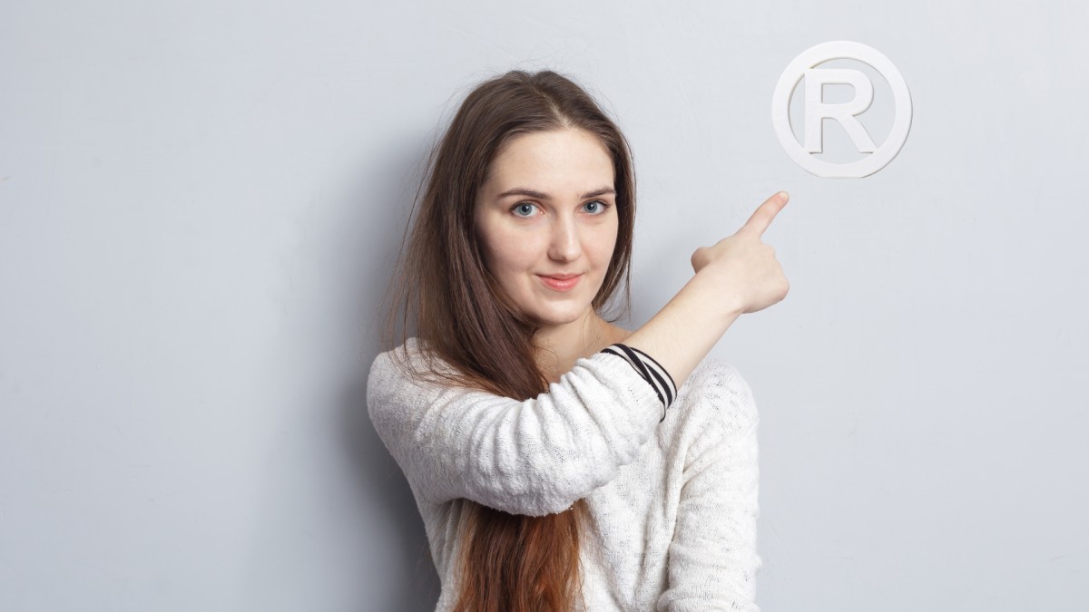 Girl arrowing towards trademark symbol